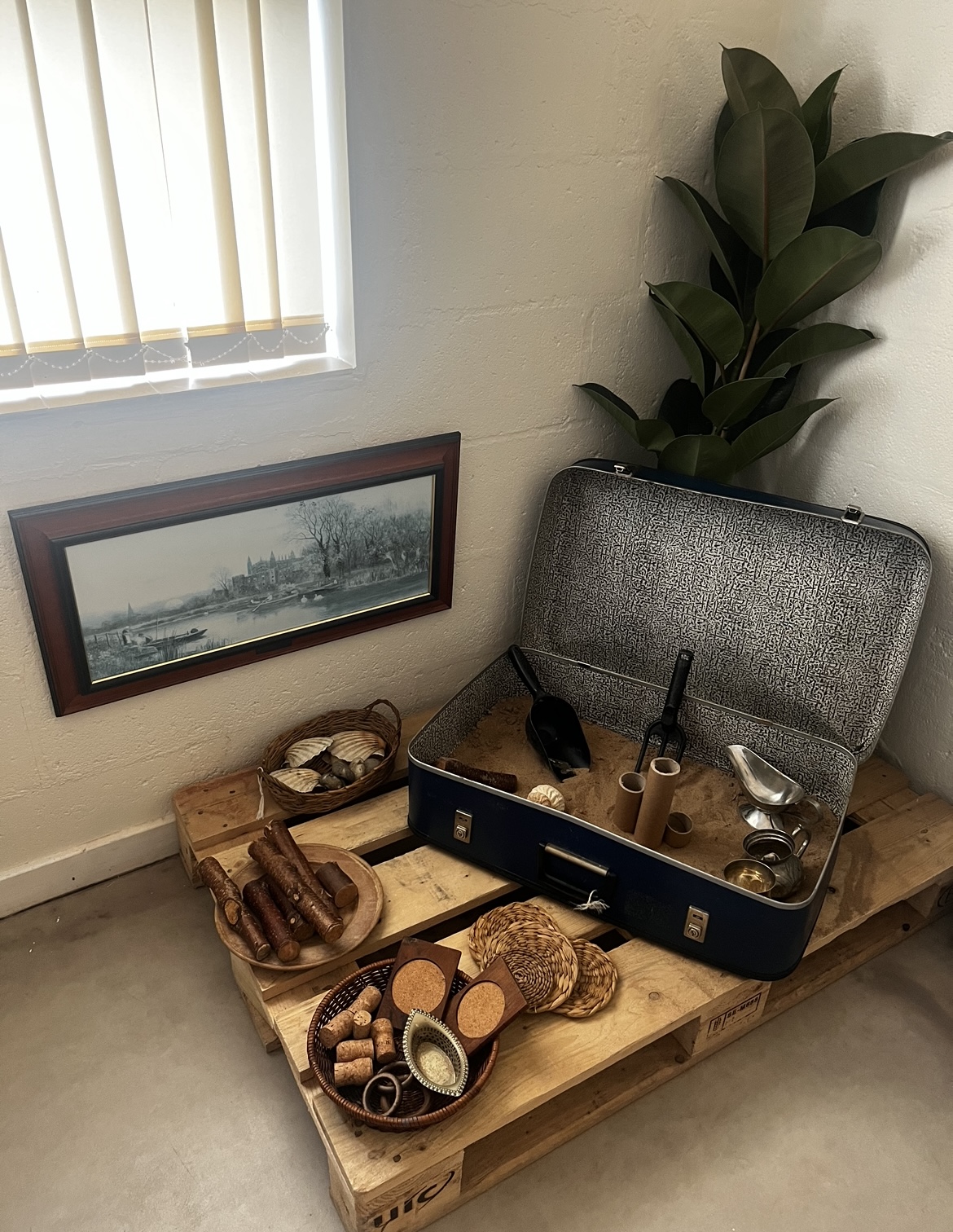 A suitcase filled with sand and digging tools